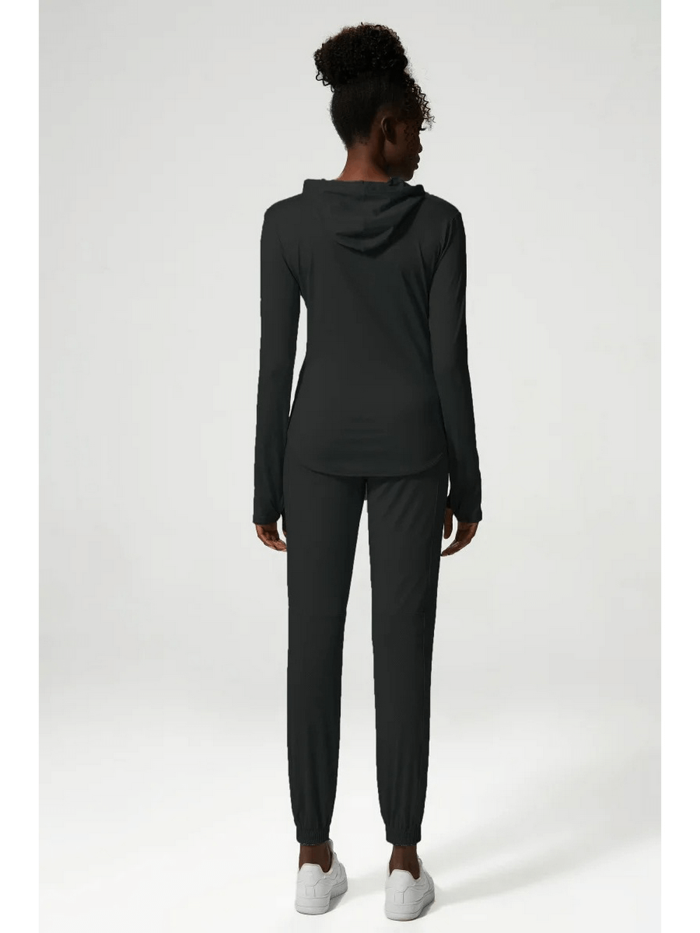 Back view of woman wearing stylish black athletic clothing set, perfect for gym or casual outings. Breathable and quick-drying fabric.